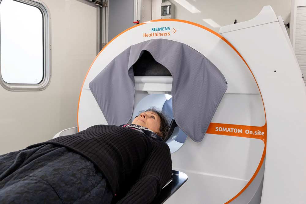 L'immagine rappresenta l'interno della Mobile Stroke Unit. In particolare si vede il tomografo in funzione su di un paziente sdraiato, all'interno dell'ambulanza.