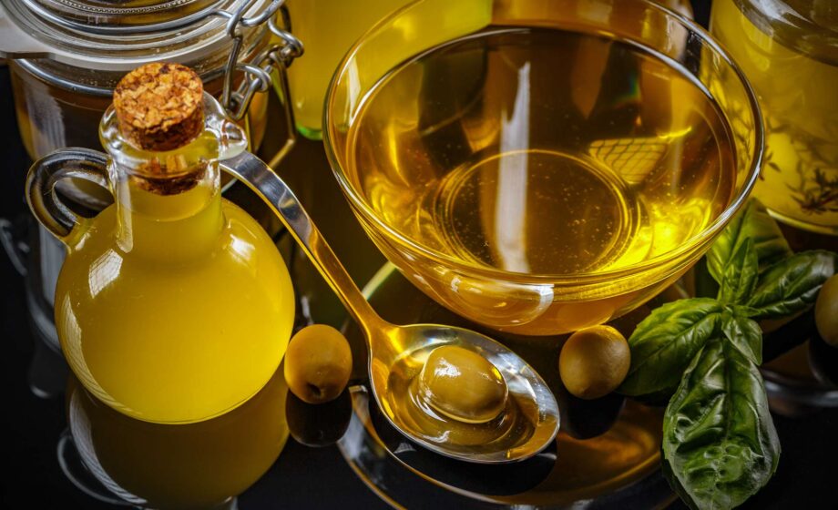 La foto raffigura una terrina contenente olio di oliva, con, di fianco, una bottiglia di olio ed alcune olive, contenenti idrossitirosolo