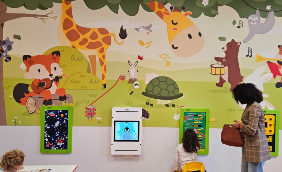 Sala giochi interattiva presso l'ospedale di Treviso. Le pareti sono colorate con disegni di animali ed al muro dei giochi interattivi, per un ospedale a misura di bambino