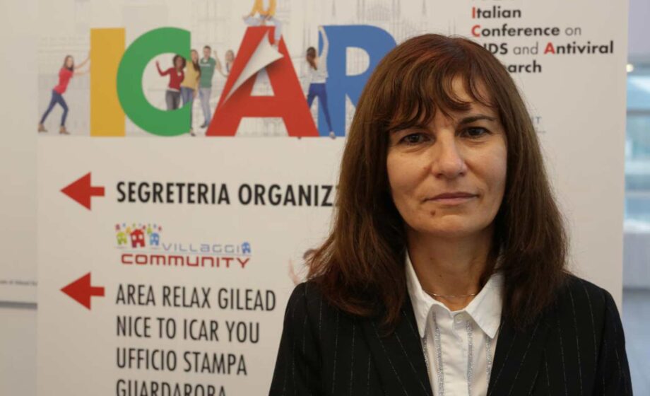 donna davanti al cartello con su scritto ICAR 2025 HIV a Padova