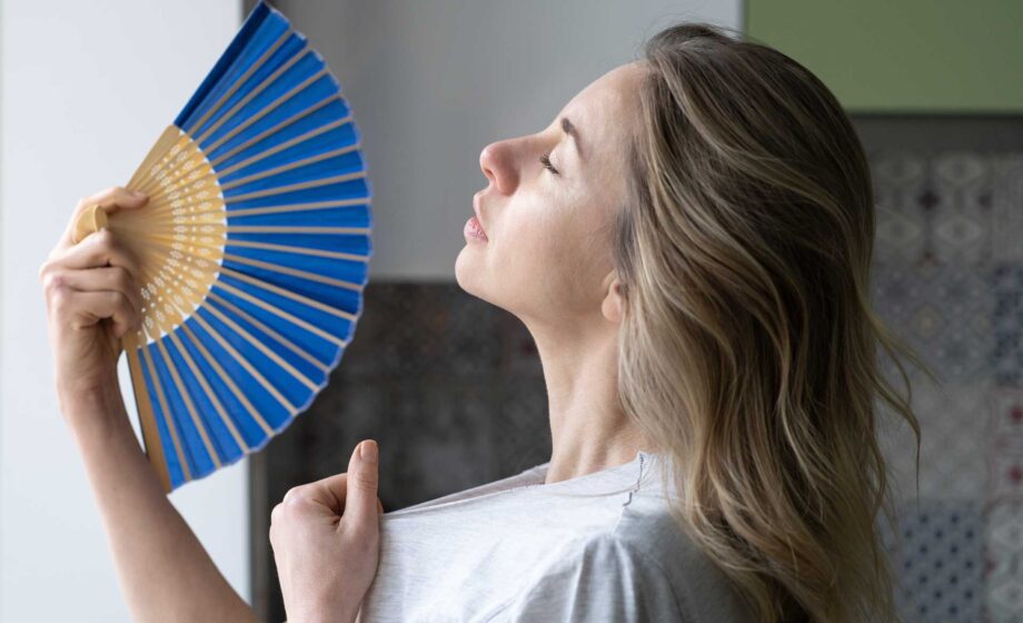 Una donna che sventola un ventaglio perché sente caldo. Attivo dal 23 giugno 2025 il servizio 1500 caldo per aiutare i cittadini durante le ondate di calore.