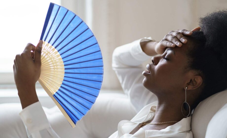 Donna che sventola un ventaglio perché sente caldo