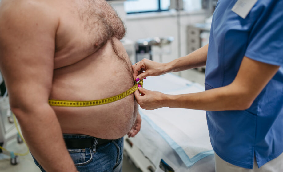 Misurazione con un centimetro, da parte di un medico, dell'addome di un paziente obeso